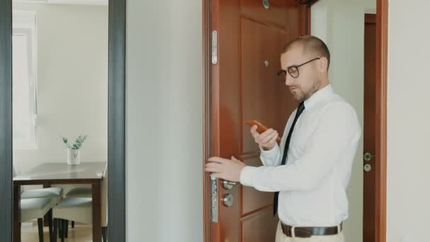 Man geeft thuis van het werk met telefoon en zijn vrouw ontmoette hem — Stockvideo