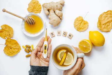 Çay ve termometre, limon, zencefil, tatlım, sekme ile eller