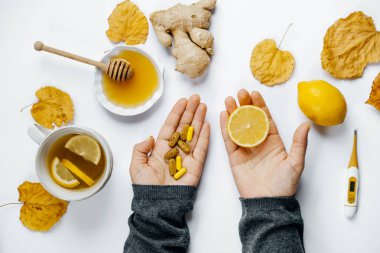 Kadın elleriyle Tablet ve limon, çay, termometre, zencefil, ho