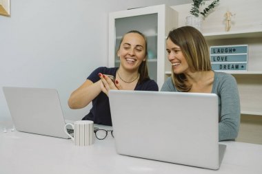 Telefon gülümseme ile işaret ve bazı tartışmaya iki genç kadın