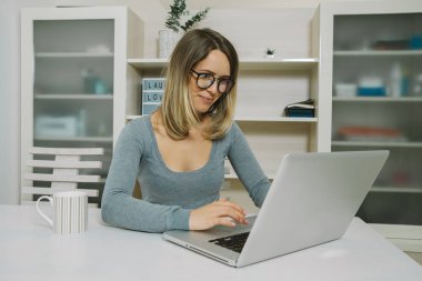 Genç kadın çalışma Üniversitesi projesi ile laptop. 