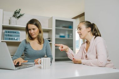 Kadın arkadaşları bir proje ve içinde laptop işaret tartışmak