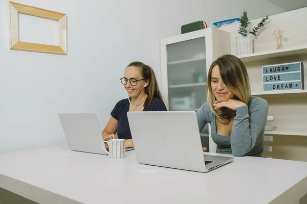 Dvě mladé ženy pracují na přenosný počítač v kanceláři — Stock fotografie