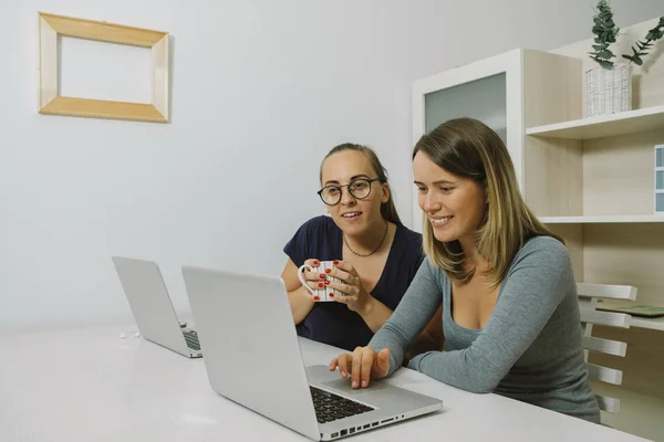 두 젊은 여성이 미소 노트북 고 솜을 논의 — 스톡 사진