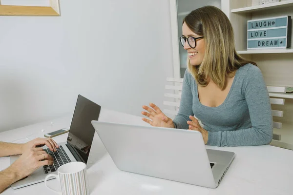 Deux collègues travaillant ensemble sur un ordinateur portable au bureau — Photo