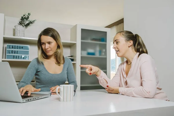 Des collègues femmes discutent d'un projet et pointent du doigt un ordinateur portable dans le — Photo