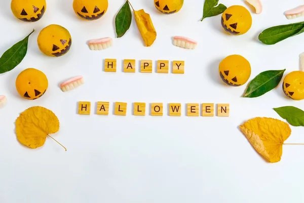 Happy Halloween with fake pumpkins and tangerines with painted s — Stock Photo, Image
