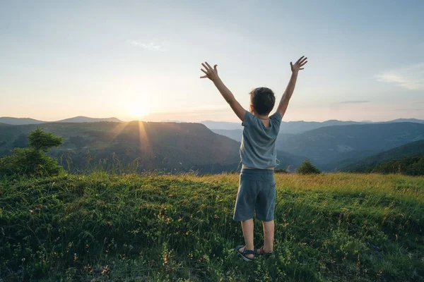 Gyerek fiú felemelte a kezét, szemben a háttérben a ruhát hegyi — Stock Fotó