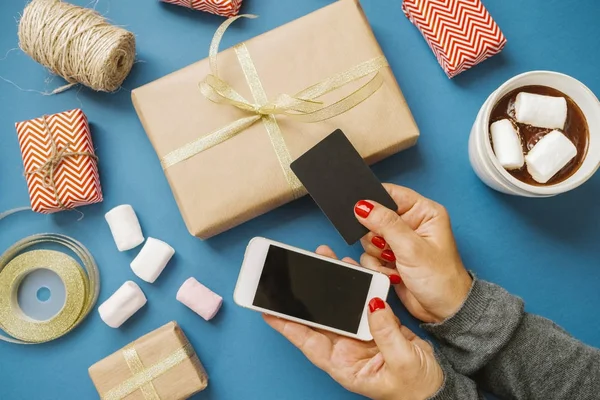 Mãos de mulher com cartão de crédito e presentes de telefone Cacau Marshmallow — Fotografia de Stock