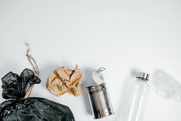 Отдельные отходы с пластиковой бутылки банка олова и бумаги на белом
  