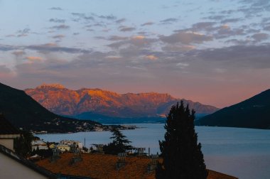 Gece şehir, mavi deniz ve yüksek dağ tepe görüntülemek