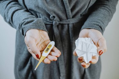 Bir termometre ve bir mendil ile eller. Soğuk kavramı