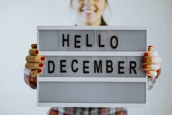 Woman hands holding board writing hello december