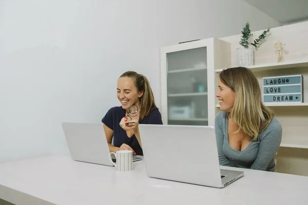 Dvě ženy, které pracují společně s přenosným počítačem v kanceláři — Stock fotografie