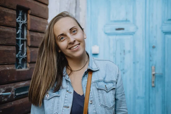 Retrato de uma jovem mulher em um fundo de parede azul — Fotografia de Stock