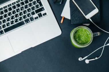 Sağlıklı kavramı. Masaüstü yeşil smoothie ve siyah laptop ile
