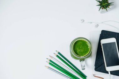 İleti örneği ve beyaz t üzerinde yeşil bir smothie ile sağlıklı çalışma alanı