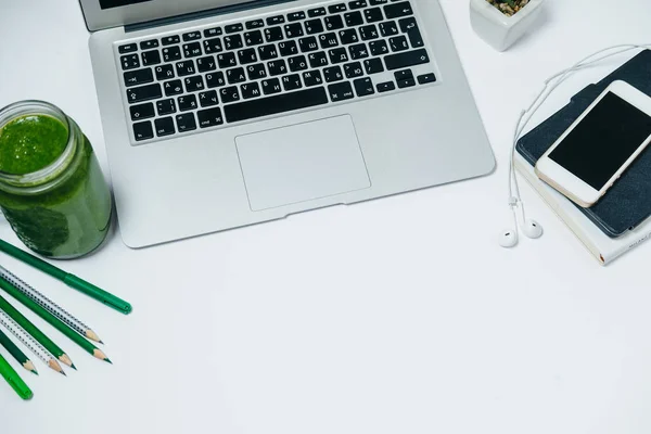 Υγιή επιφάνεια εργασίας με πράσινο smoothie και laptop σε λευκό φόντο — Φωτογραφία Αρχείου