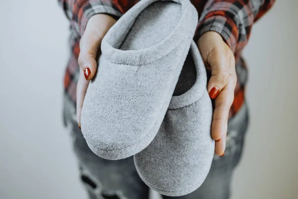 Female hands hold cozy slippers — Stock Photo, Image