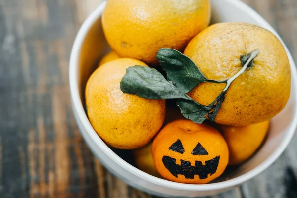 Mandarins in a bowl. Halloween with fake pumpkins and tangerines — Stock Photo, Image