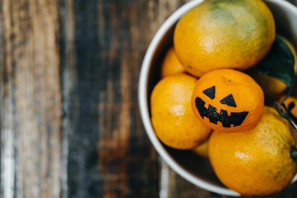Mandarins in a bowl. Halloween with fake pumpkins and tangerines — Stock Photo, Image