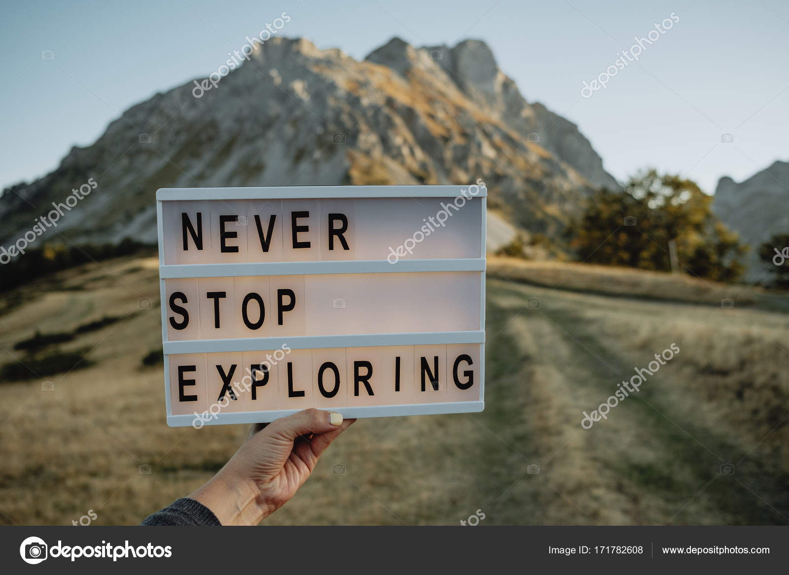 Never Stop Exploring Board In Woman Hands Against The Background Stock Photo C Haribol 108