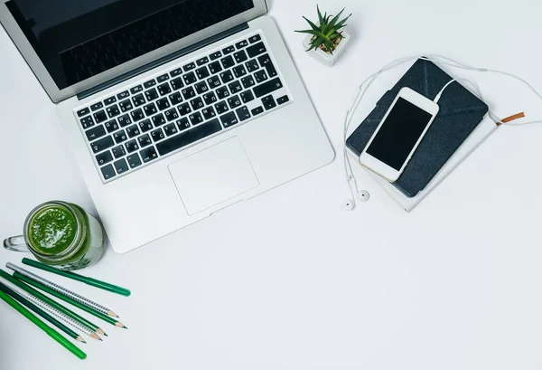 Υγιεινό χώρο εργασίας με πράσινο smoothie και laptop σε λευκό backg — Φωτογραφία Αρχείου