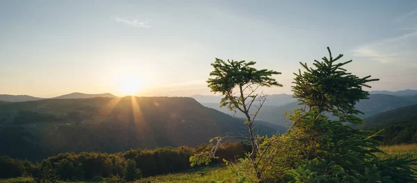 Lichtstrahlen strömen durch Wolken über Gebirge — Stockfoto