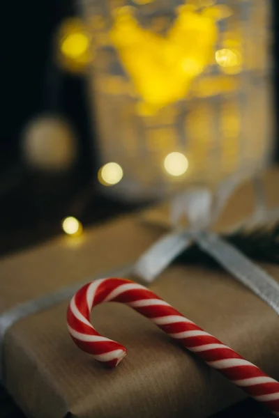 Regalo de Navidad con bastones de caramelo y rama de abeto en w oscuro —  Fotos de Stock