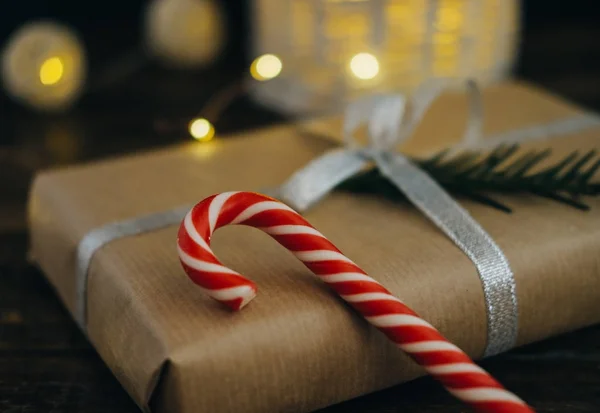 Nahaufnahme Weihnachtsgeschenk mit Zuckerstangen und Tannenzweig — Stockfoto