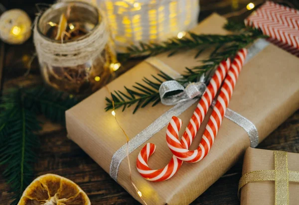 Χριστουγεννιάτικο δώρο με καλάμους καραμελών και υποκατάστημα δέντρο έλατο στο σκούρο w — Φωτογραφία Αρχείου