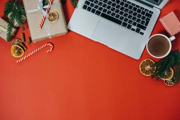Área de trabalho de Natal com laptop, chocolate quente, doces no bac vermelho — Fotografia de Stock