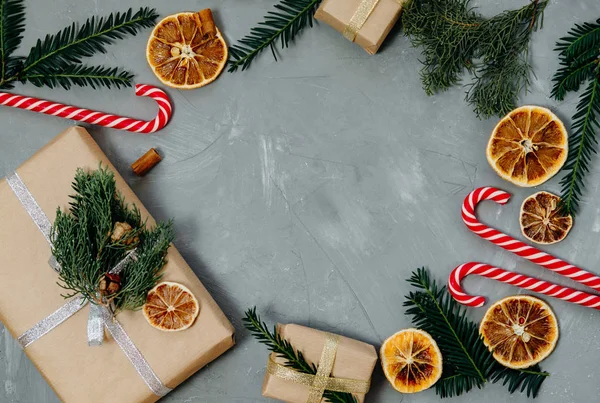 Χριστουγεννιάτικο φόντο με ένα στεφάνι, καραμέλα, ξηρό πορτοκαλί και δώρα — Φωτογραφία Αρχείου