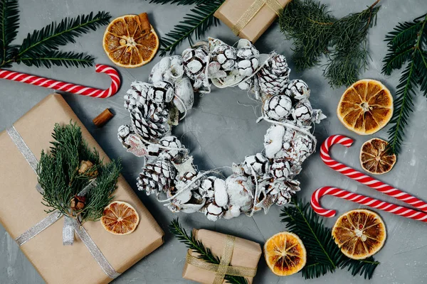 Fondo de Navidad con una corona, dulces y regalos en una ba gris —  Fotos de Stock