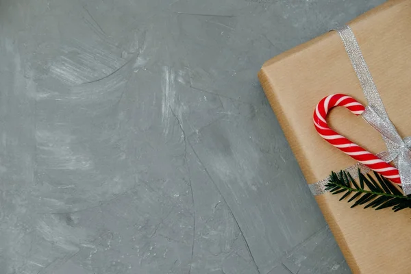 Nahaufnahme Geschenk und Weihnachtsbonbons auf grauem Hintergrund. Ansicht von oben, — Stockfoto