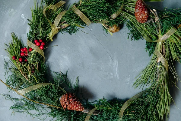 Christmas wreath with fir cones on gray concrete background. Top — Stock Photo, Image