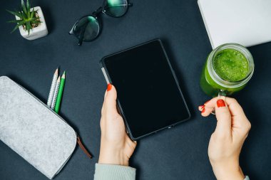 Kadın el ve kavanoz üst görüntülemek Tablet ile taze yeşil smoothie