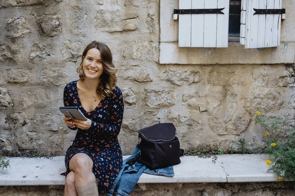 Genç neşeli kadın bir e-kitap açık okuma