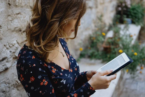 Fechar-se Jovem alegre mulher lendo um e-book ao ar livre — Fotografia de Stock