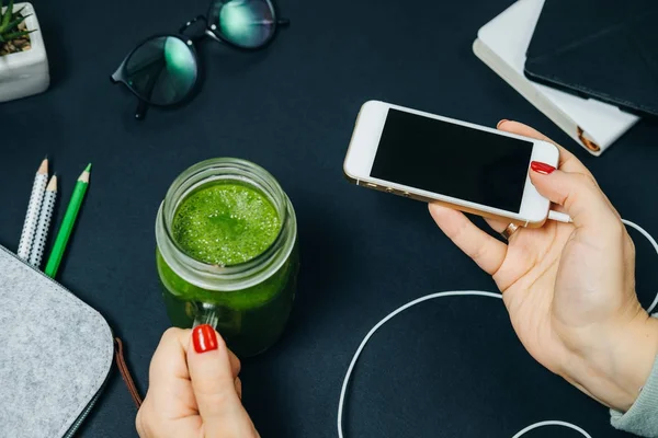 Memur, taze yeşil smoothies ile kadın el ve kavanoz telefon