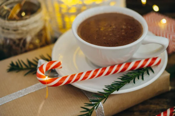 Tasse heiße Schokolade mit Geschenk, Zuckerstangen und Tannenkleie — Stockfoto