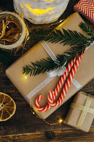 Χριστουγεννιάτικο δώρο με καλάμους καραμελών και υποκατάστημα δέντρο έλατο στο σκούρο w — Φωτογραφία Αρχείου