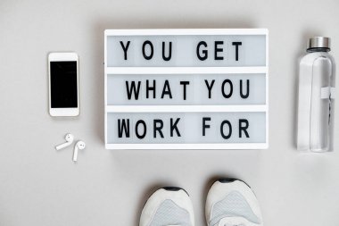 Spor motivasyon. Üzerinde gri bir backg telefon ve spor ayakkabı Üstten Görünüm