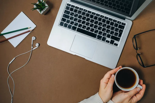 Female hands with laptop, spectacles and coffee cup on Brown Off — Stock Photo, Image