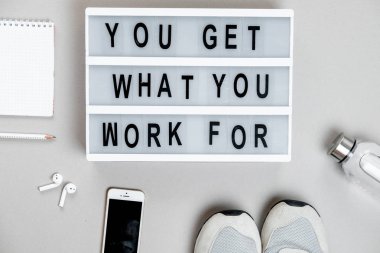 Su, telefon ve spor ayakkabılar üzerinde gri bir backgr spor arka plan