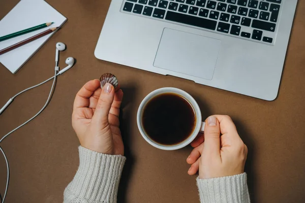 Área de trabalho da mulher. Mãos femininas com xícara de café e laptop em marrom — Fotografia de Stock