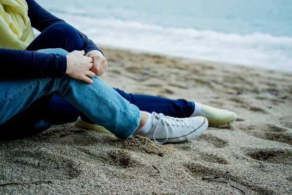 Primer plano pareja sentada en la playa y mira el mar en autum — Foto de Stock