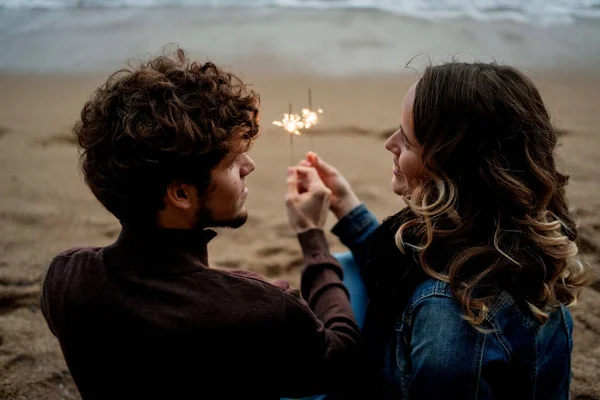 Vista posteriore della giovane bella coppia felice che tiene scintille di nuovo — Foto Stock