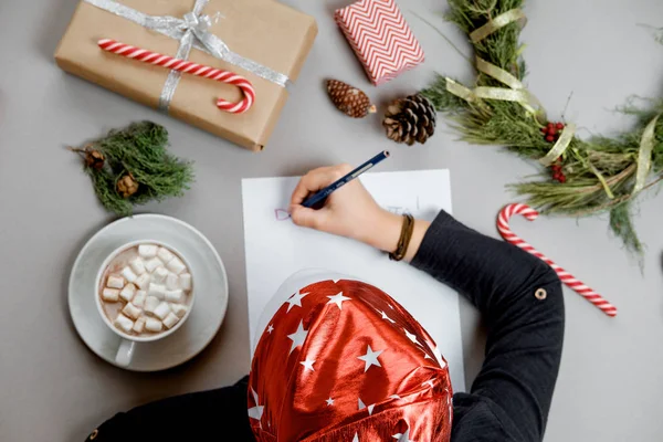 Carta para o Pai Natal. Mãos de rapaz sobre papel, presentes e marshmallows. Para — Fotografia de Stock