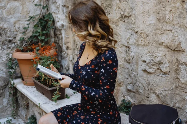 Joven mujer alegre leyendo una tableta al aire libre — Foto de Stock